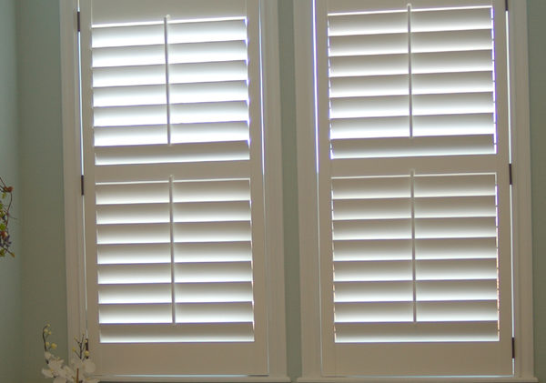 master bathroom with custom white plantation shutters on windows above tub