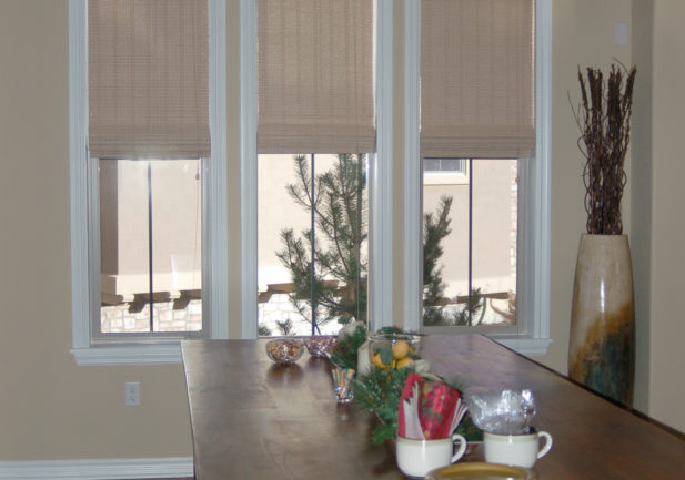 neutral woven wood shades on three windows in Denver dining room windows