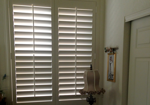 white hinged panel shutters on large window in Westminster CO