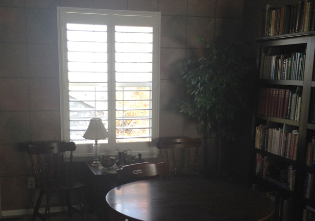white vinyl shutters on tall window in home library in Denver CO