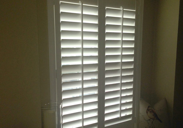 front tilt hinged panel shutters on window in Denver CO