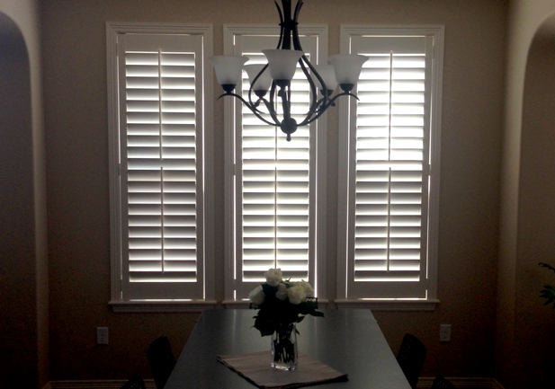 three narrow windows in dining room with plantation shutters in Englewood CO