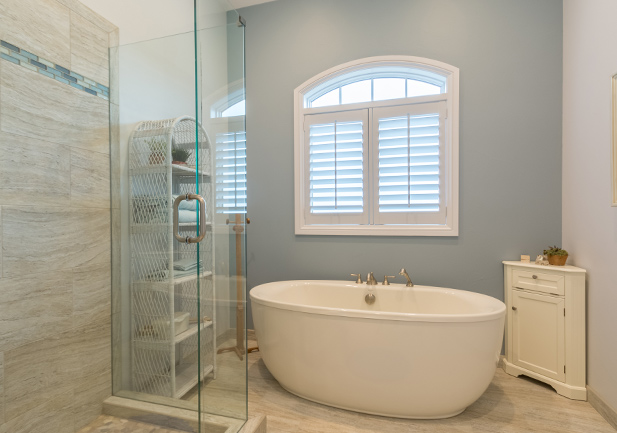 master bathroom with arched window and white plantation shutters in Westminster CO