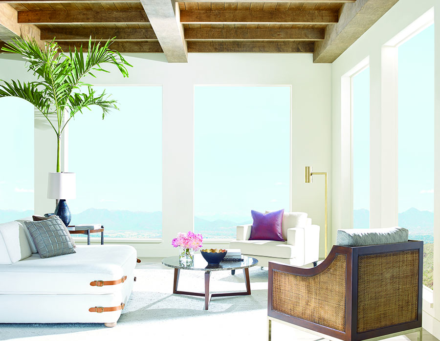 Living room with bare floor to ceiling windows.