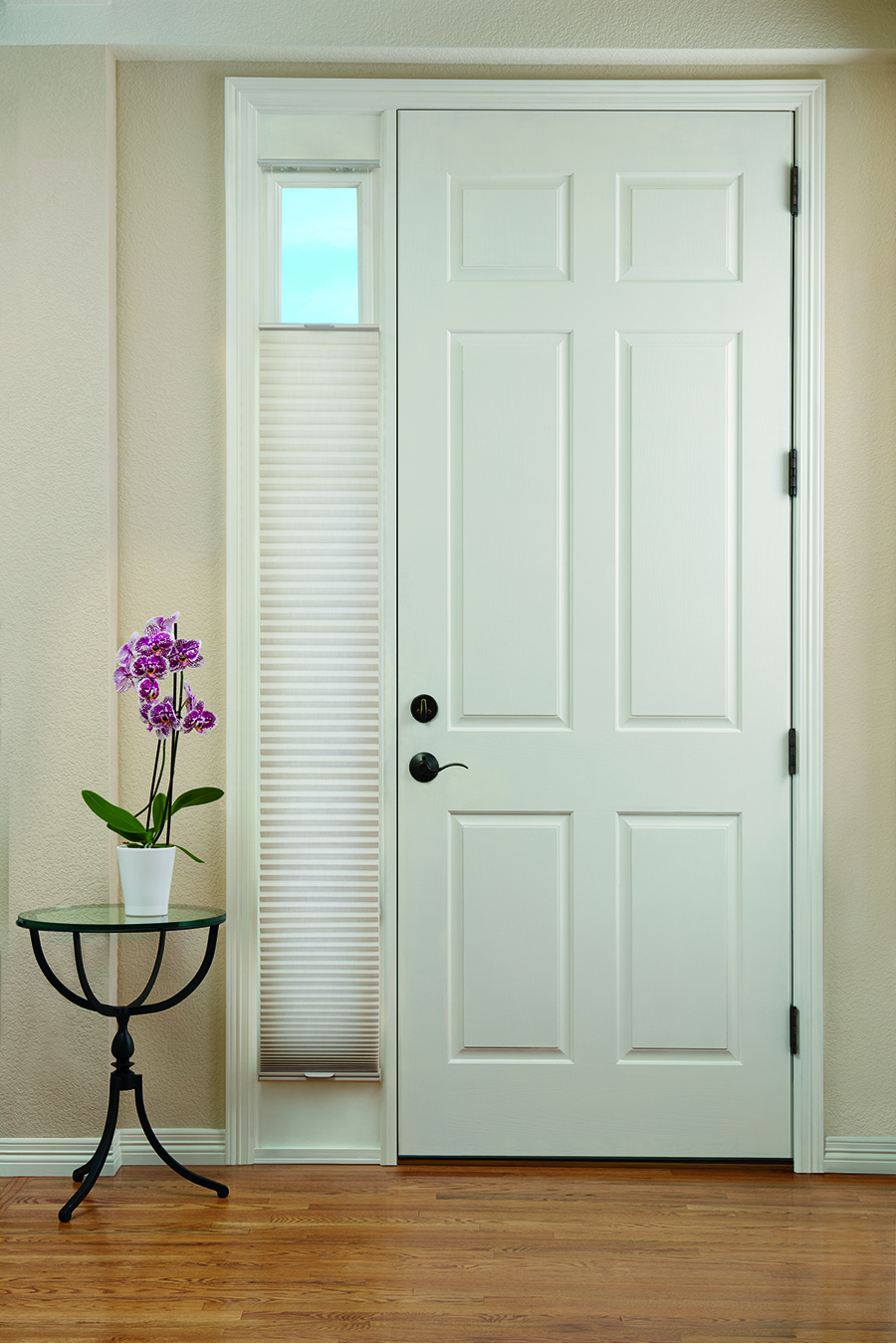 Sidelights on entryway door covered with honeycomb shades.