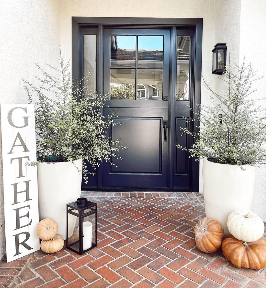 exterior entryway black door with white planters and fall decor