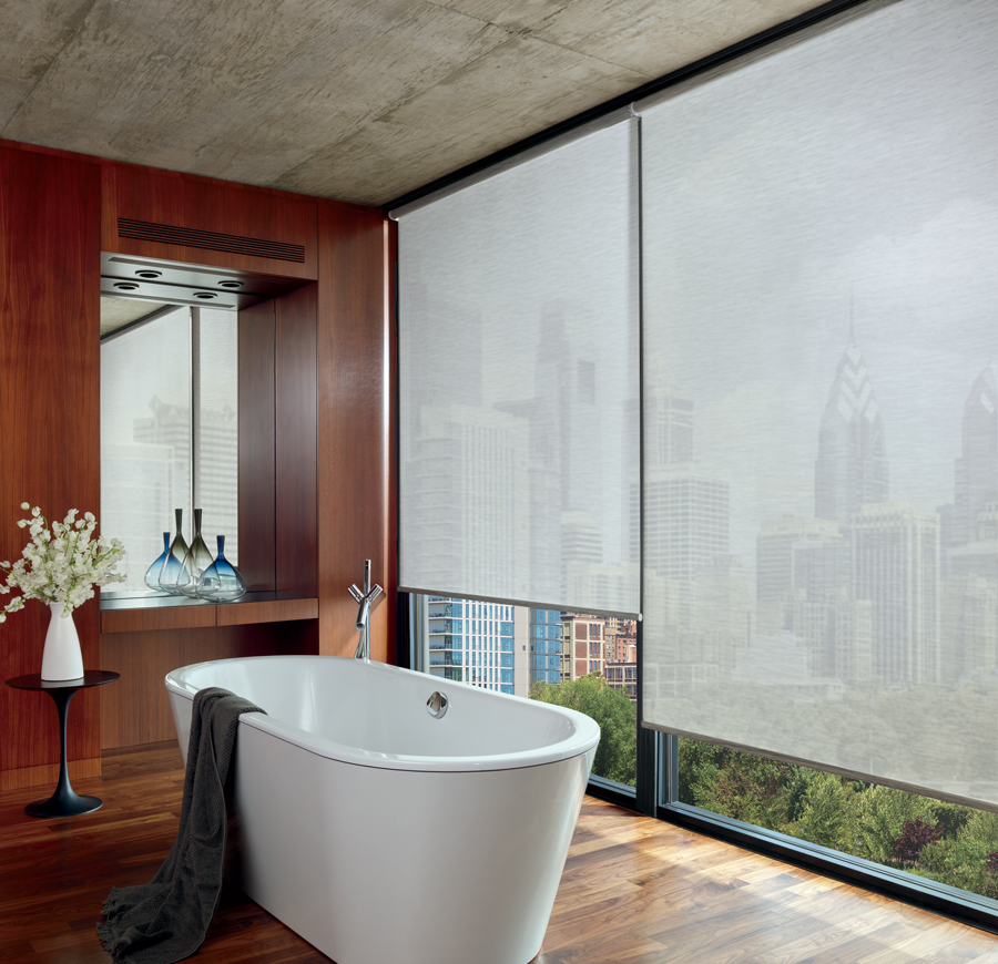 bathroom in highrise condo with wall to wall windows covered with roller shades