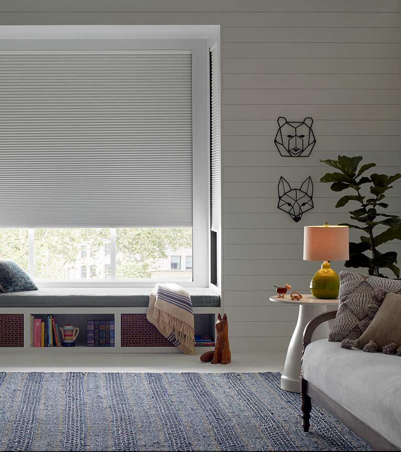 partially opened room darkening Hunter Douglas window shade in modern kids playroom