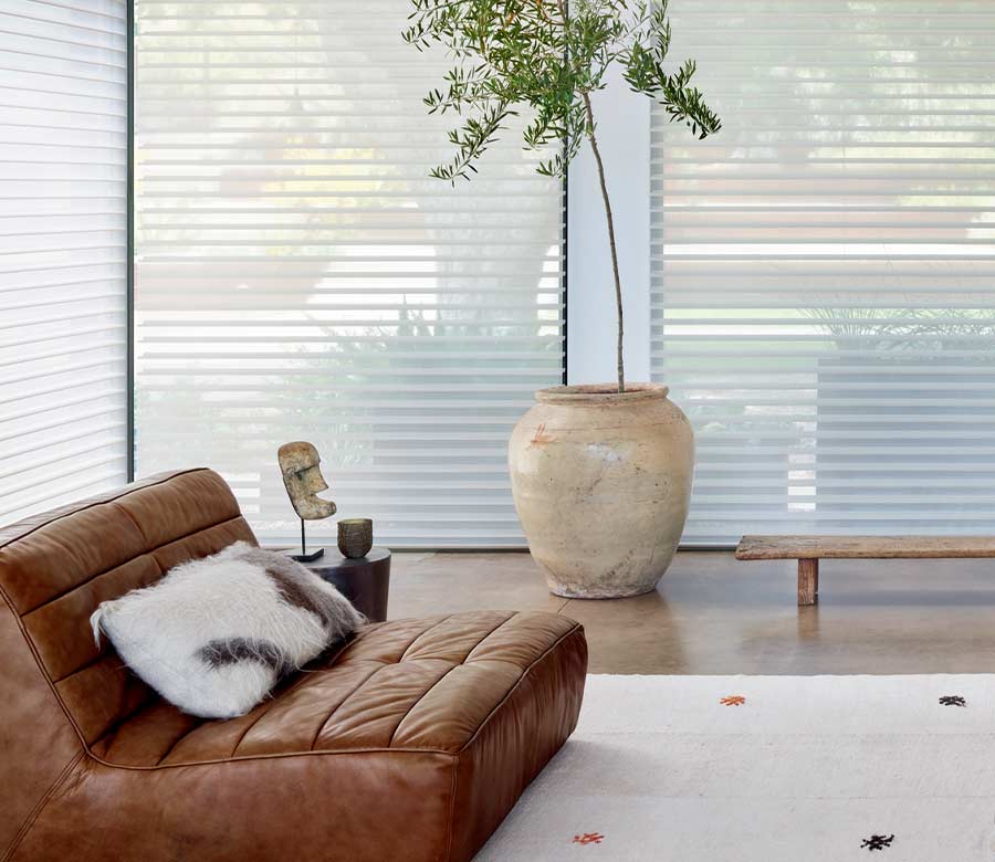 floor to ceiling shades next to leather lounger and large potted tree in Park Meadows, CO