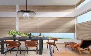 Neutral dining room with beige window treatments and a black dining table and chandelier