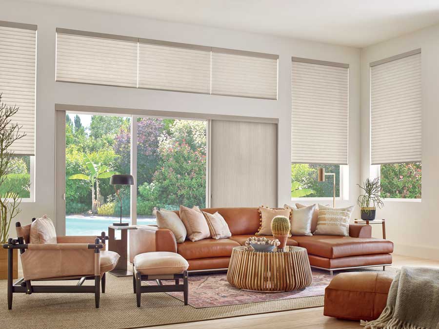 living room in an open floor plan with shades on windows and doors