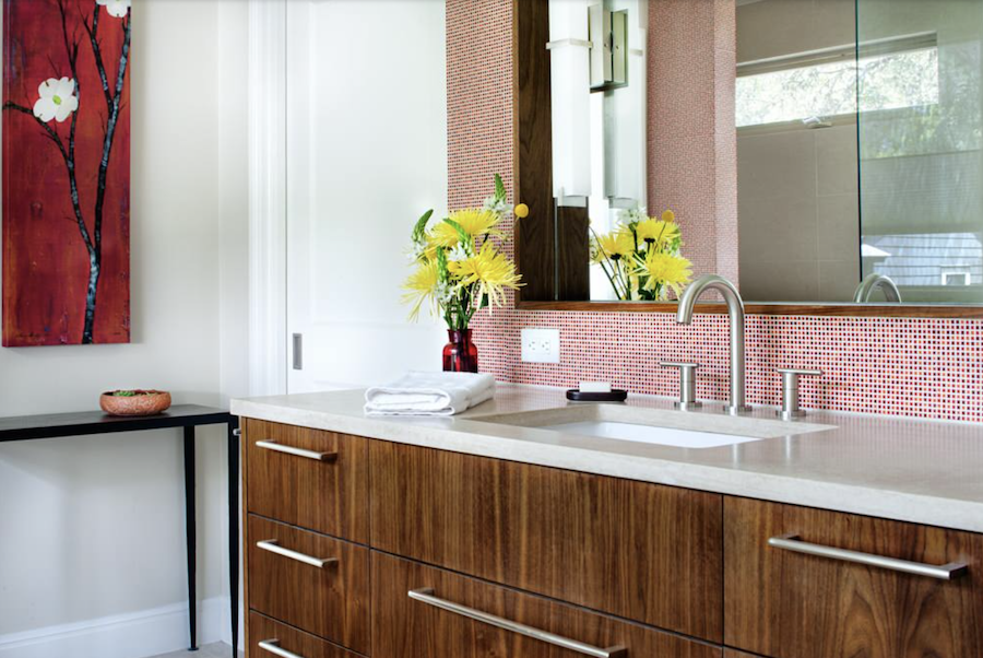 Modern bathroom with wood vanity, white walls and red tile backsplash