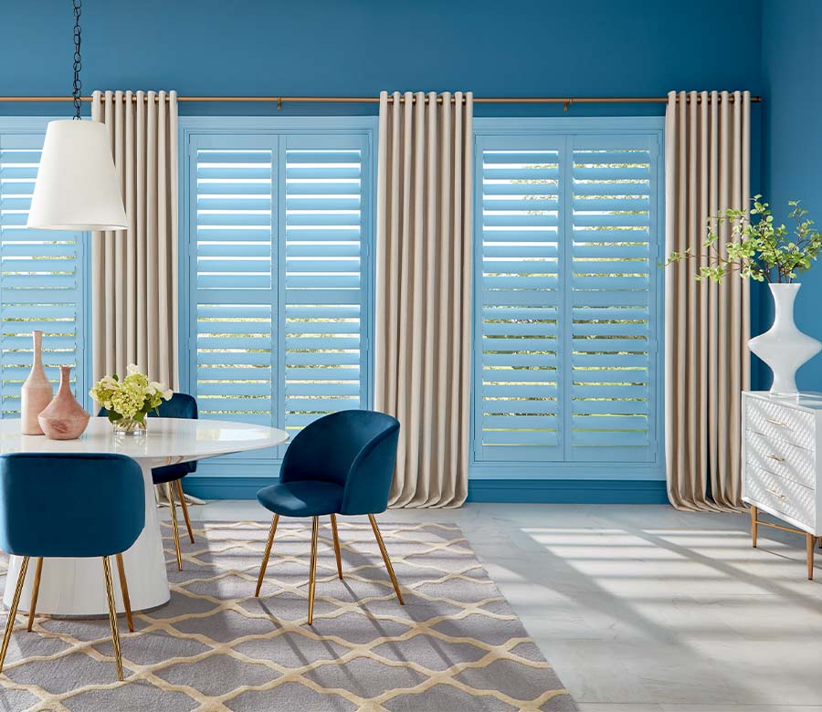 blue wooden shutter painted a pale blue in modern dining room space with drapery