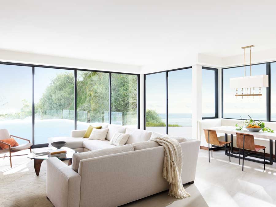 Floor to ceiling black trim windows in a living area overlooking scenery