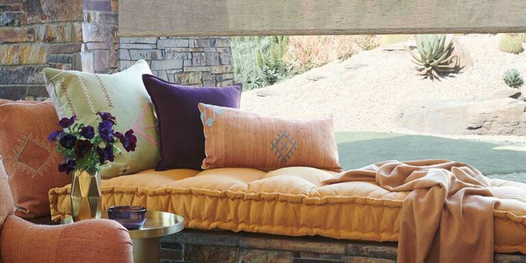 window seat with burnt orange cushion and accent pillows