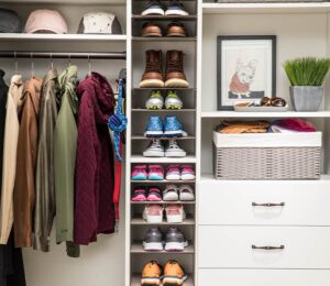 reach-in closet with adjustable shelves for shoes and hats, baskets for storage, drawers and hang bar