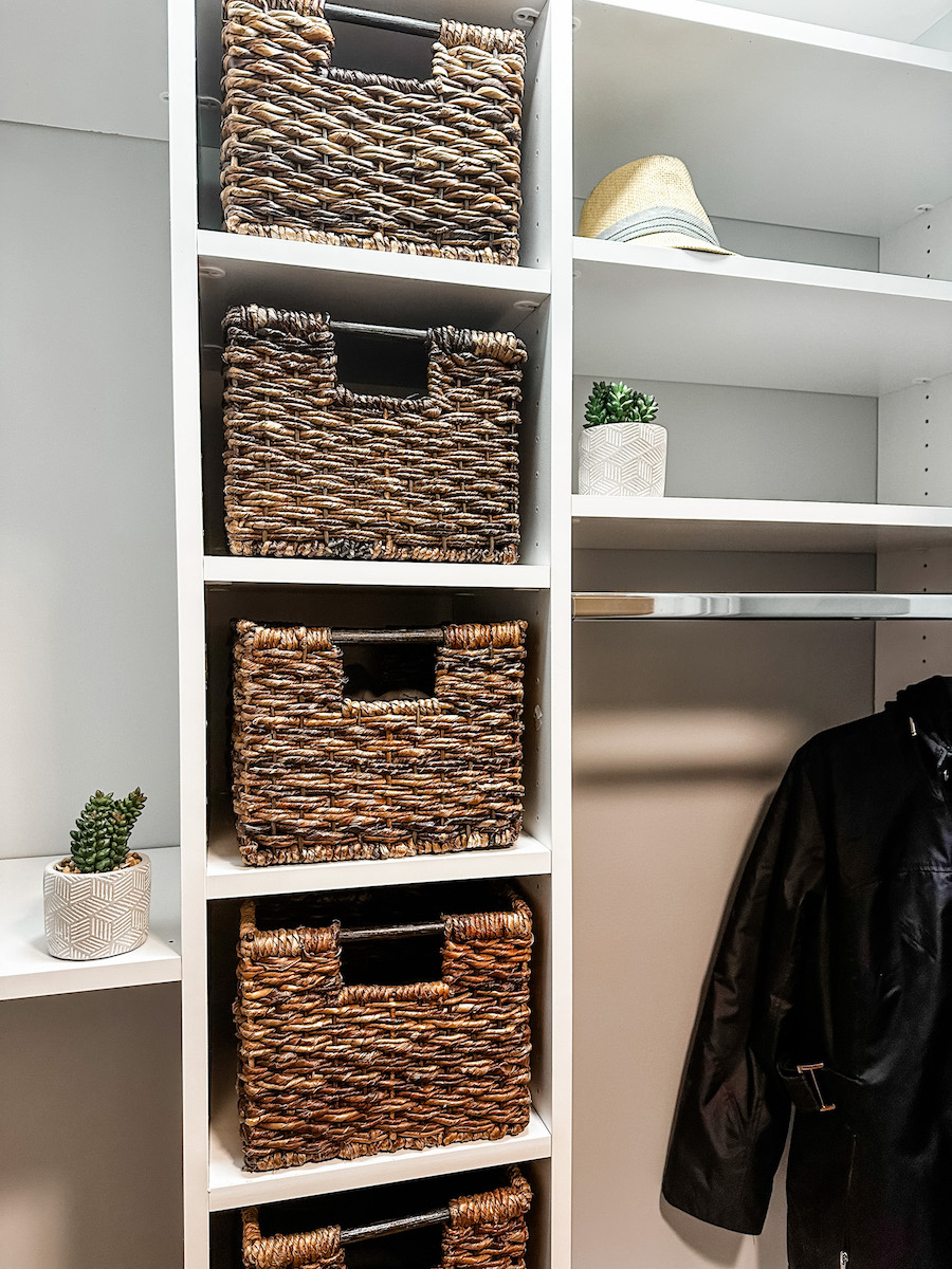 front closet with closet system installed with hang bar and woven baskets