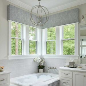 Gray cornices in the bathroom with two windows coming together in the corner of a bathroom above a bathtub