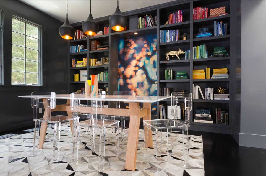 dining room with black shelves colored books and decor and clear table and chairs