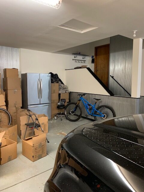 Garage before custom storage installation with limited organization and open wall space