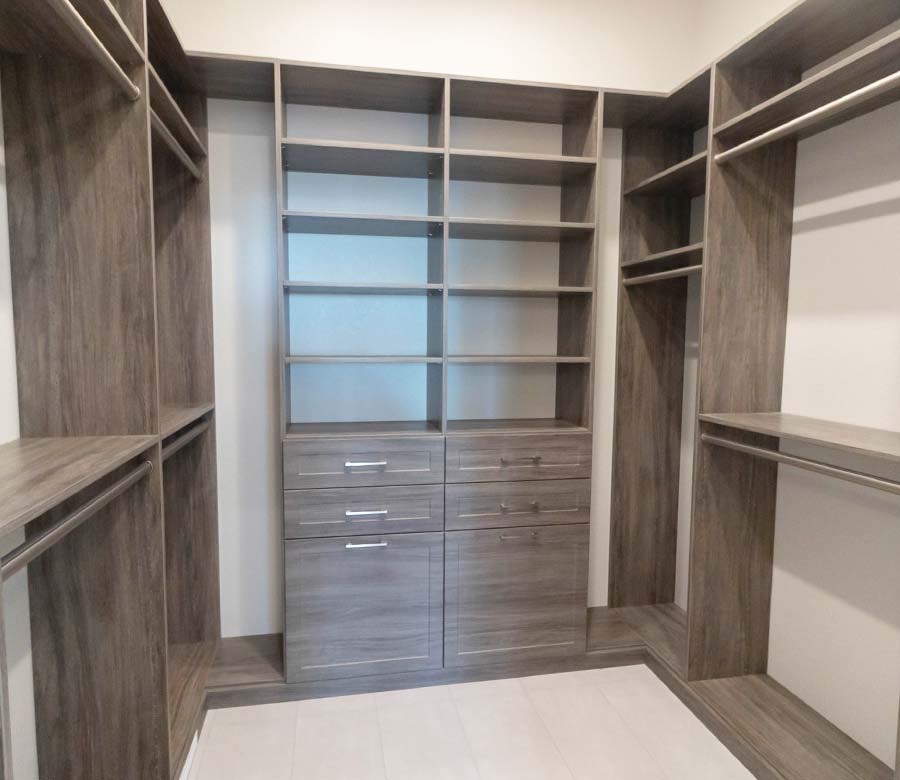 Longmont-CO-Primary-Bedroom-Walk-In-Closet-System-Rocky-Mountain-Shutters-Shades-Closets Custom walk-in closet with woodgrain storage system in Longmont, CO