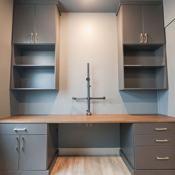 Custom basement home office in Littleton, CO, with built-in desk, drawers, and upper cabinets.
